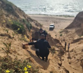 אישה חולצה ממצוק בירידה לחוף הים